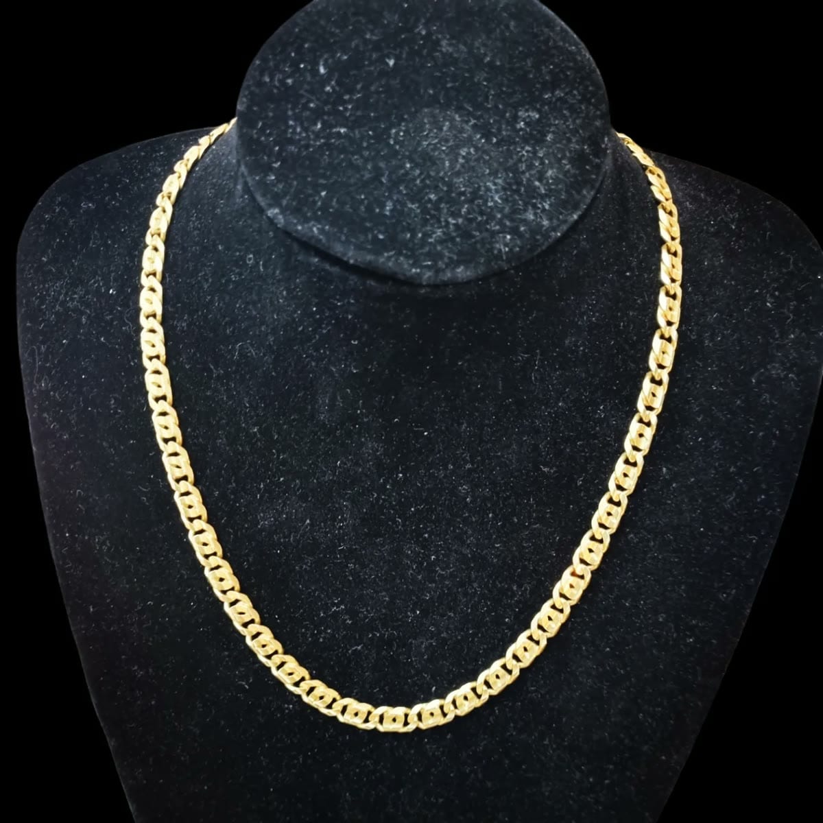 Collana in oro esposta su un busto nero